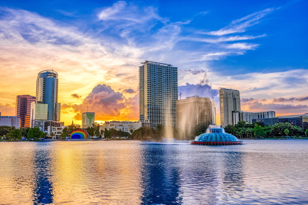 ORLANDO FL, US - May 24, 2022: Sunset and clouds over the Orlando skyline and fountain at Lake Eola Park, Orlando FL